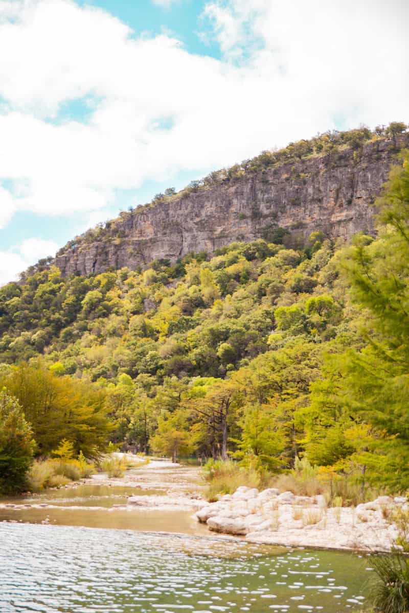 River with clear water in front of a limestone cliff