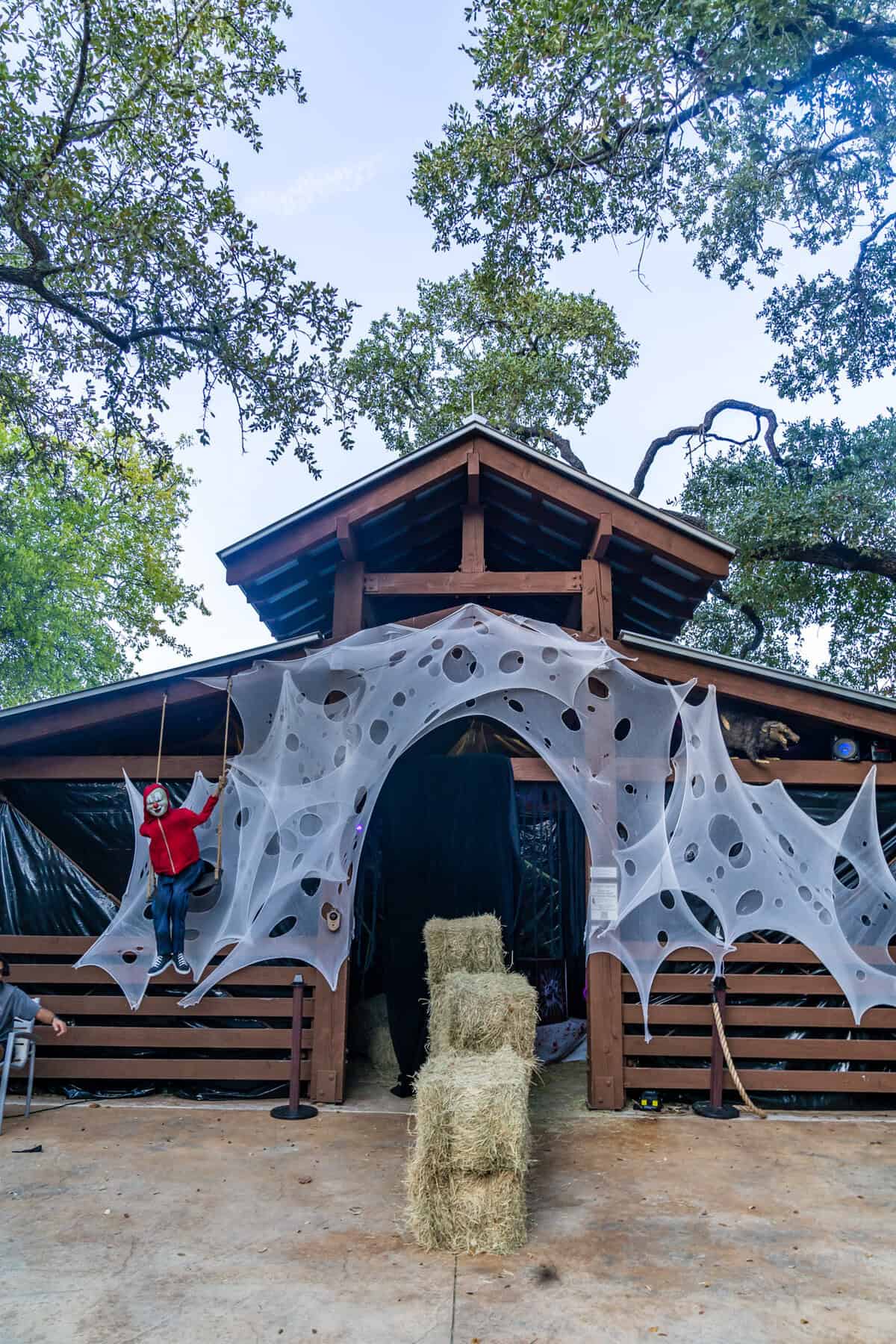 A person swinging in front of a house adorned