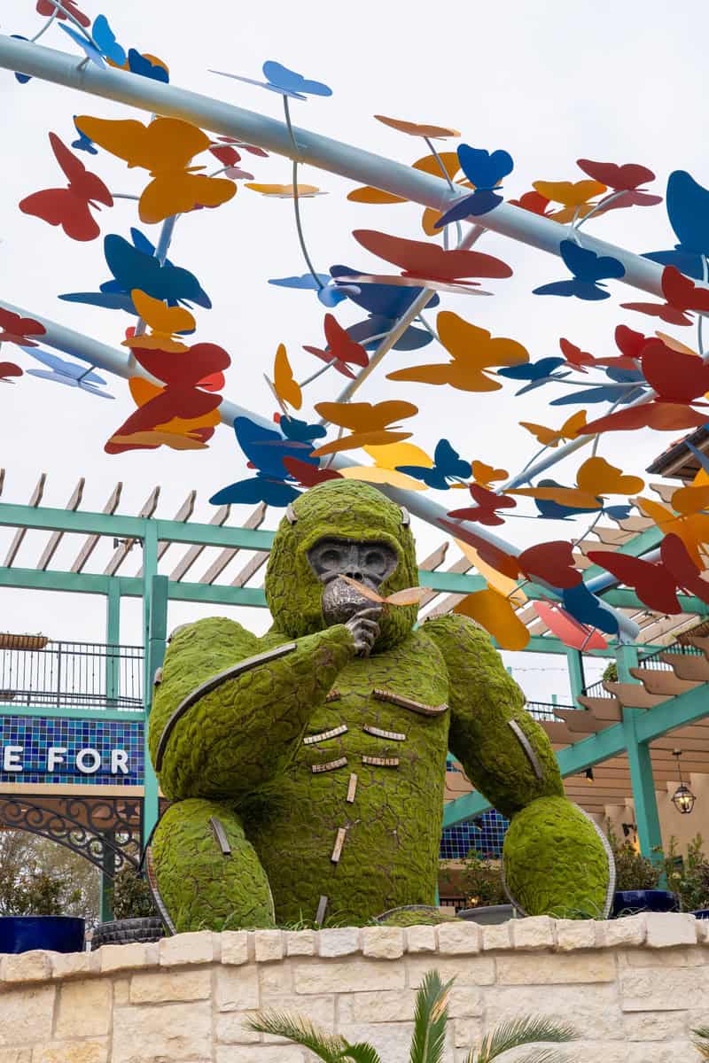 A vibrant statue of a gorilla surrounded by an array of colorful butterflies, .