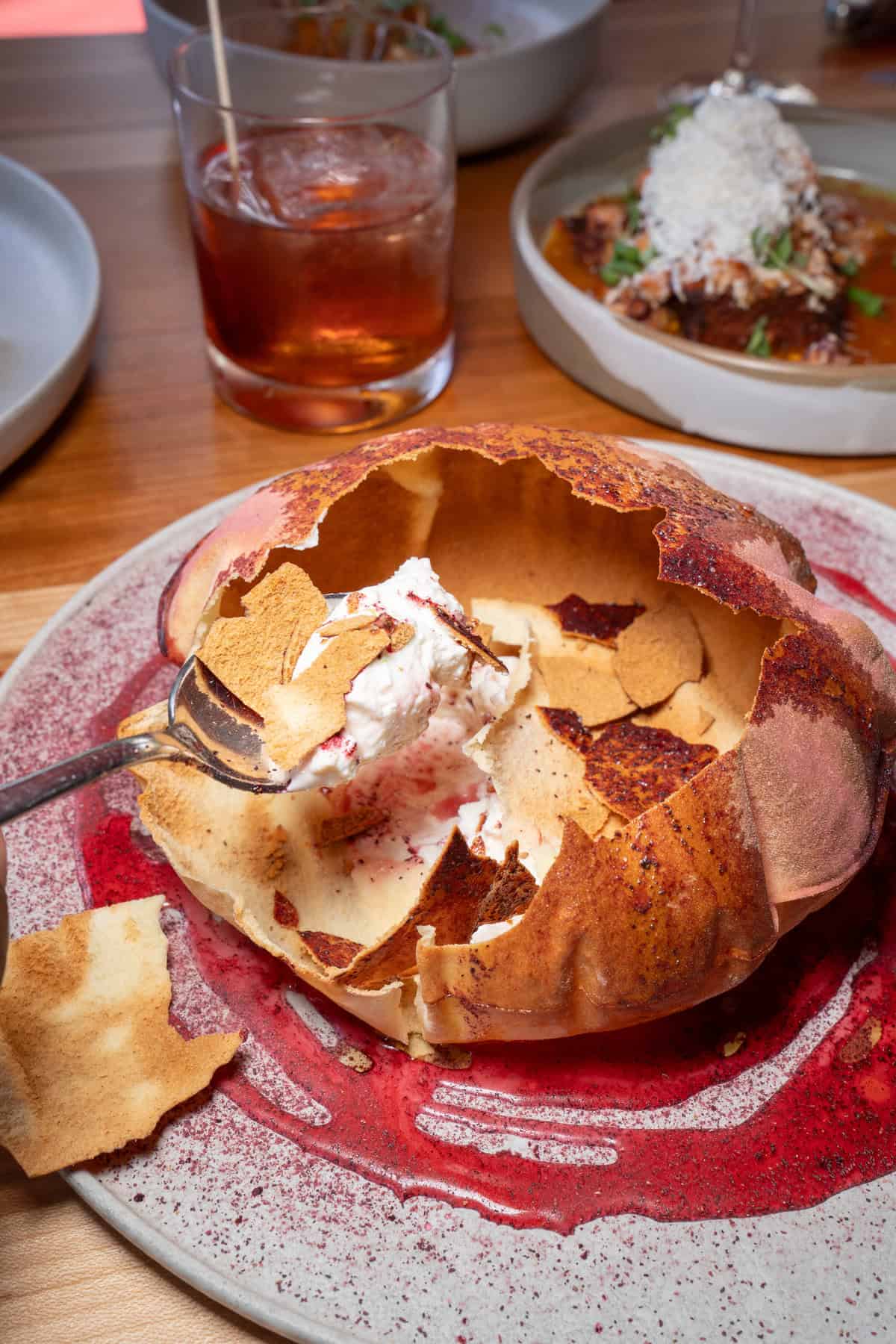 A partly eaten, hollowed round bread filled with cream