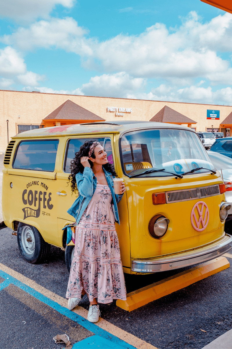 Person standing by a yellow vintage VW van