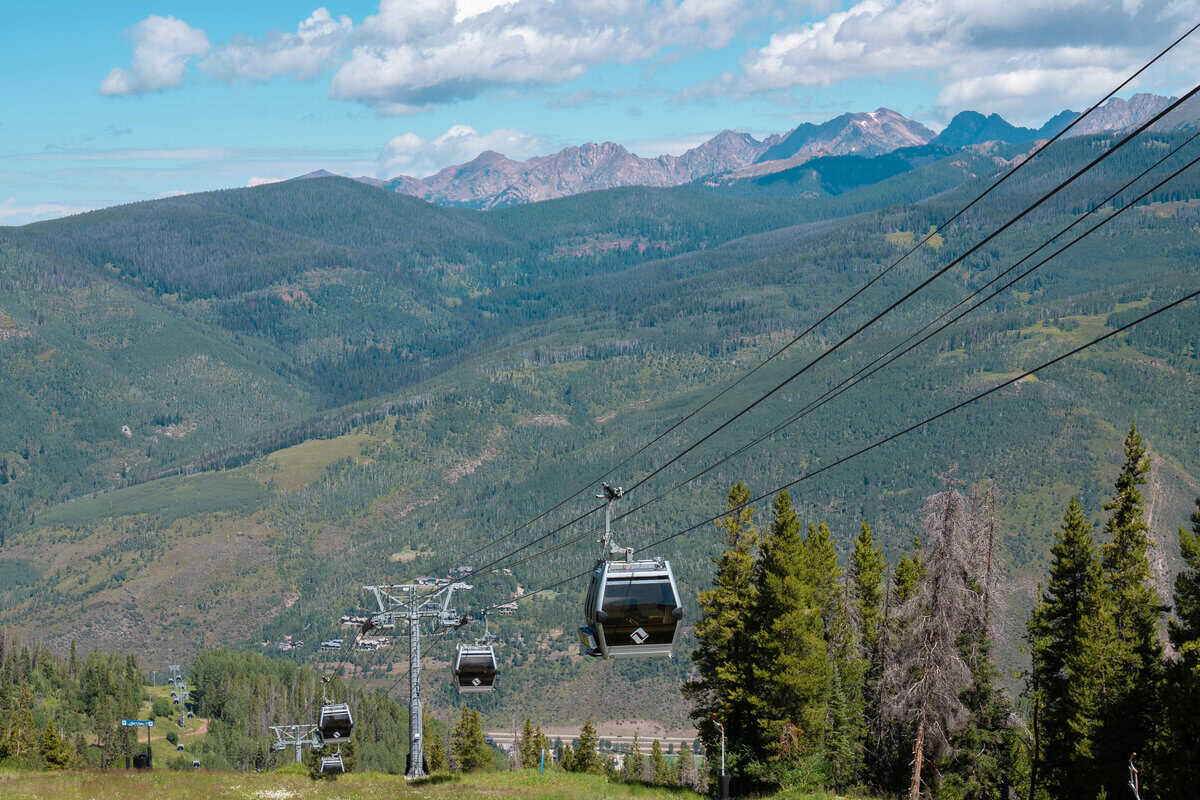 A cable car system over a green mountain landscape