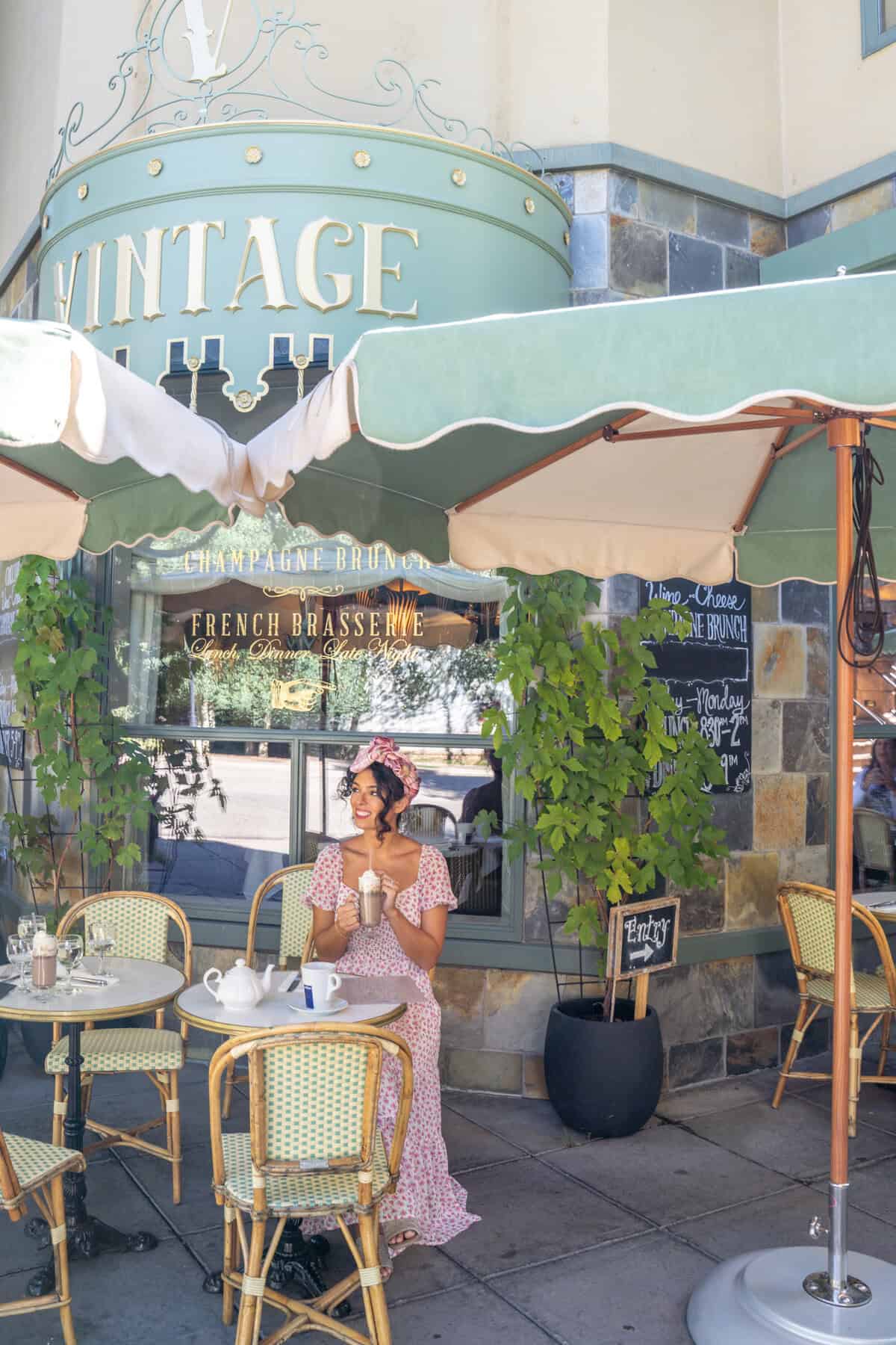 Person in a pink dress at an outdoor cafe