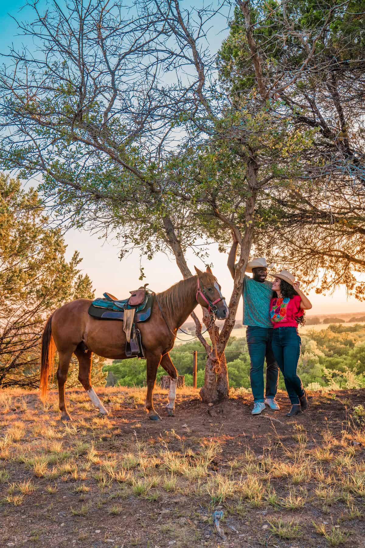 Two people and a horse under trees