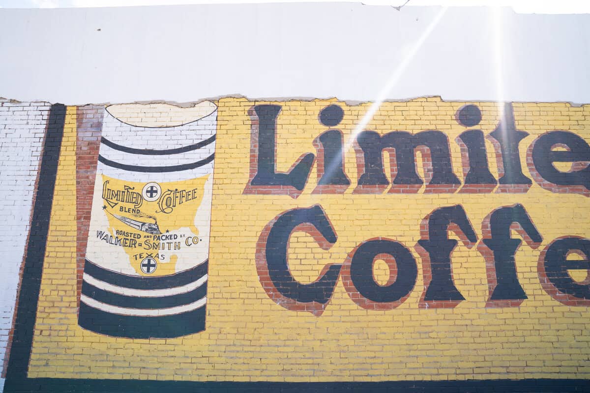 Vintage coffee advertisement mural on a yellow brick wall