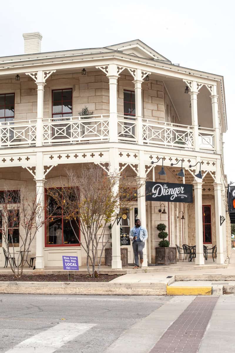 A person walks by a historic two-story building 