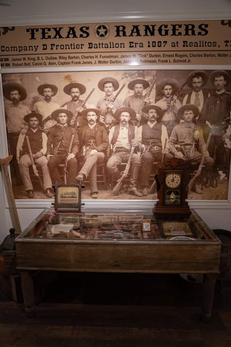 Historic photo of Texas Rangers displayed above antique items