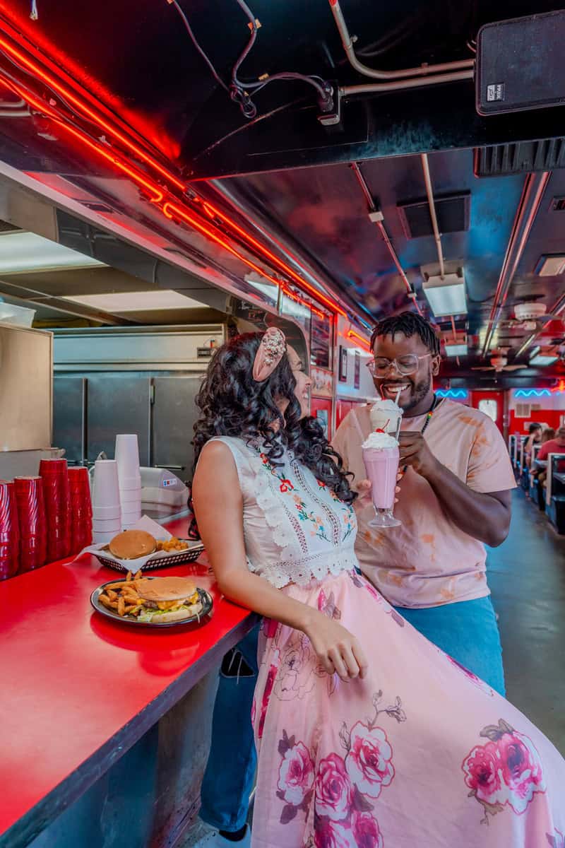 A couple enjoys drinks together at a cozy diner table