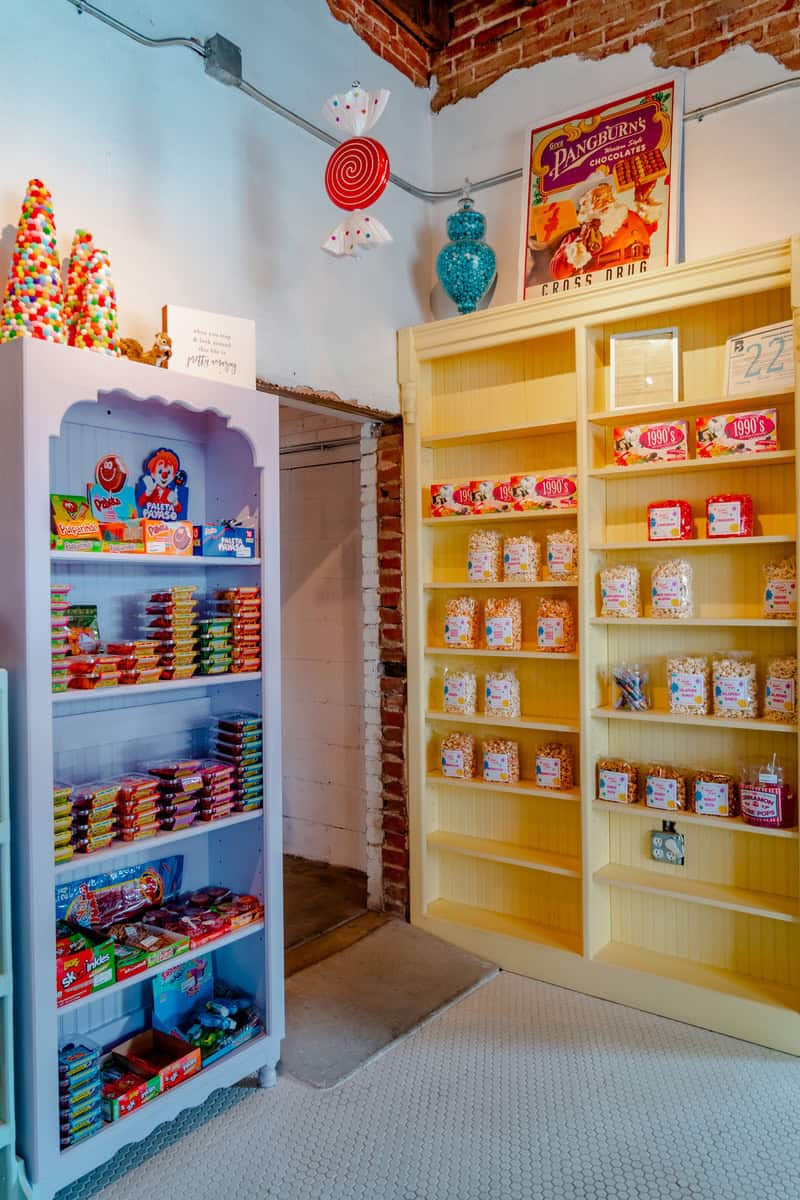 A colorful room filled with shelves stacked high with various candies