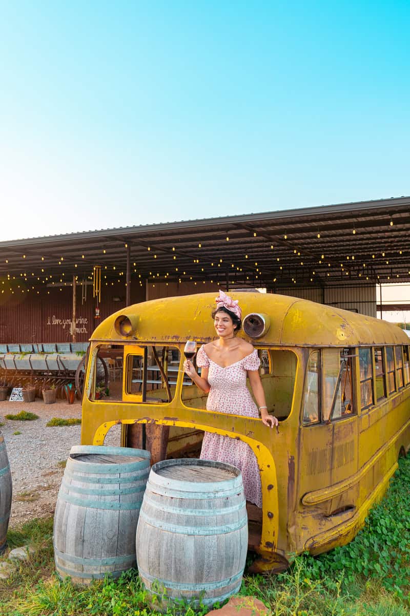 Person in a floral dress by an old yellow bus