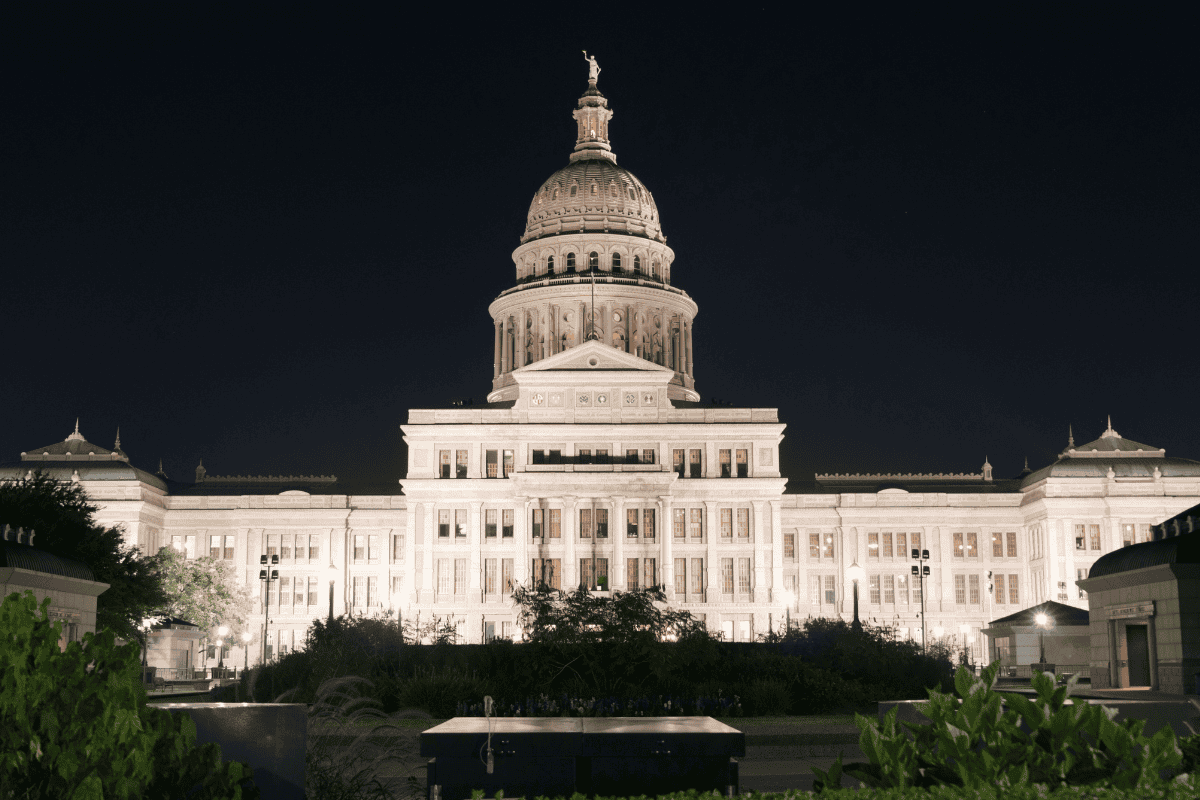 Illuminated capitol building at night with a clear sky.