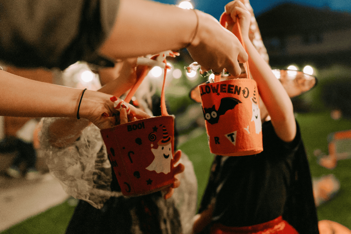 Children holding orange Halloween buckets