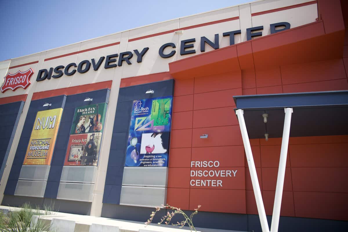 Exterior of Frisco Discovery Center with signage and colorful posters.