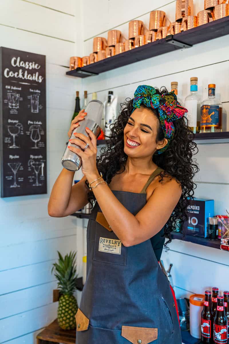 A bartender shaking a cocktail shaker at a bar