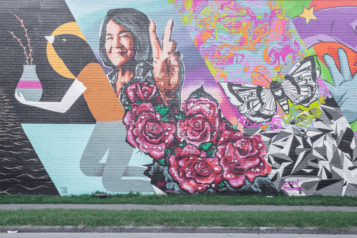 Colorful mural with roses, peace sign, abstract patterns, and a butterfly.