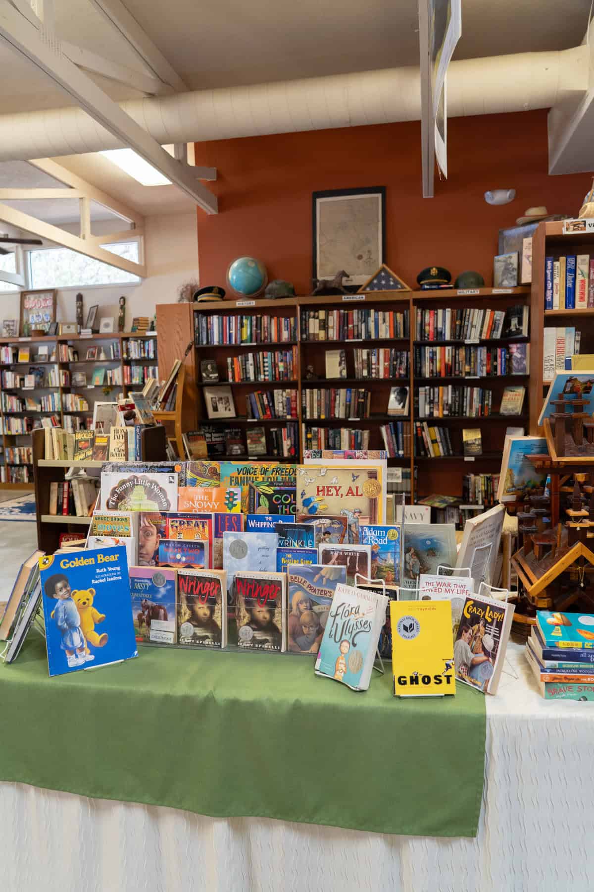 Interior of a cozy bookstore with shelves of books and a display table.