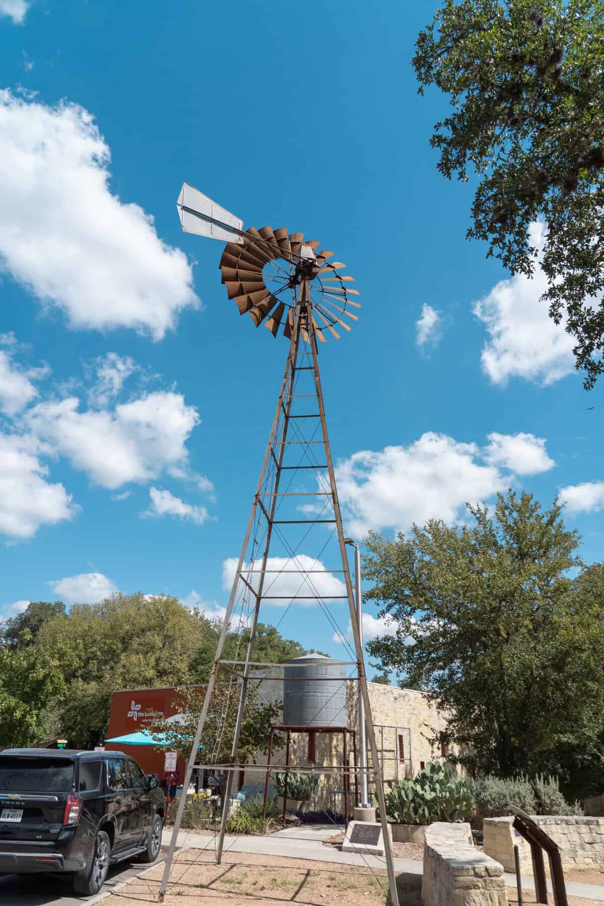 A tall metal windmill against a blue sky