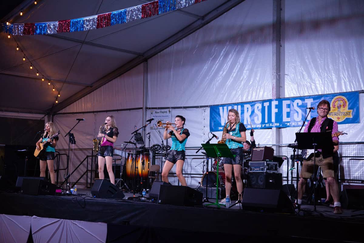 Band performing on stage at Wurstfest under a tent