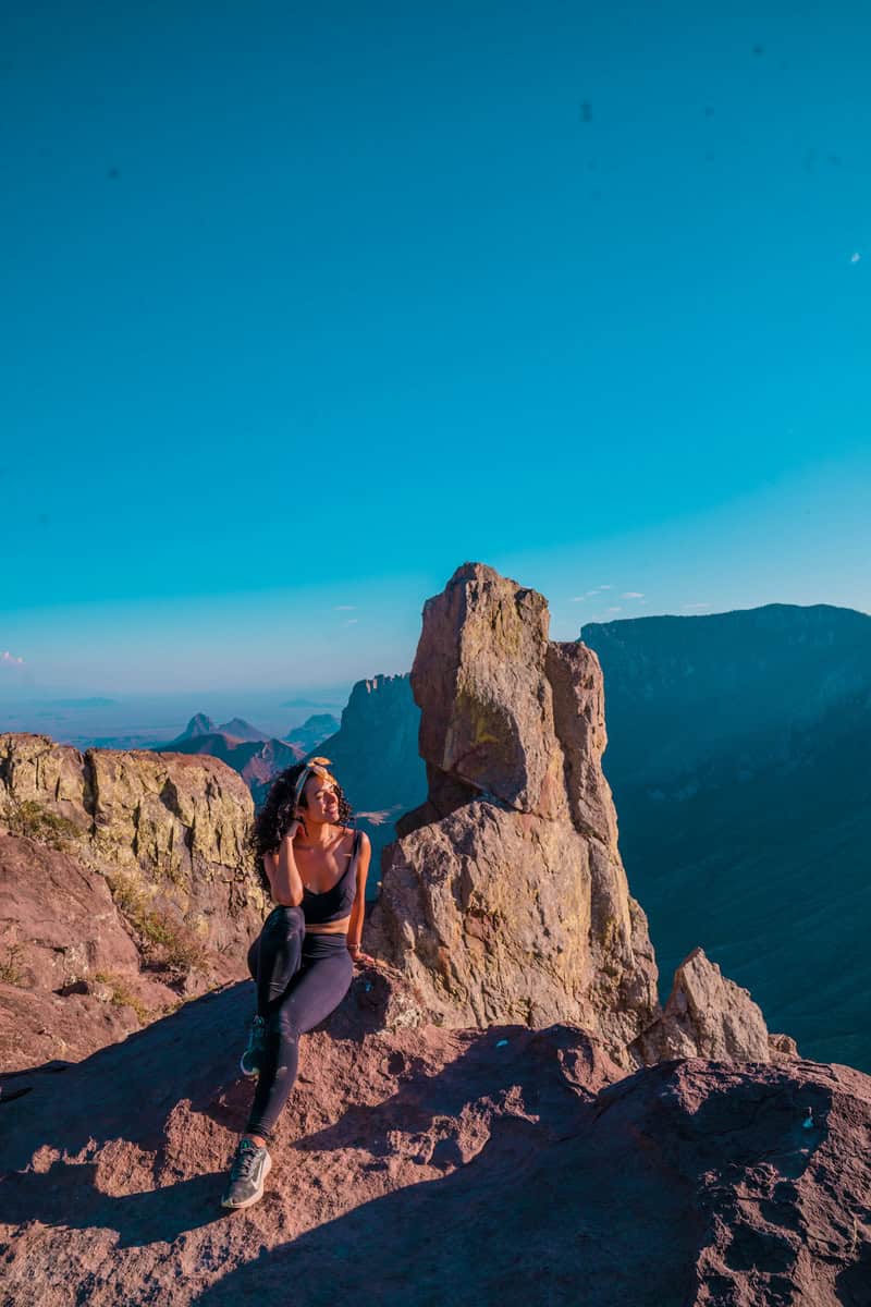 Person in activewear seated on a rocky outcrop