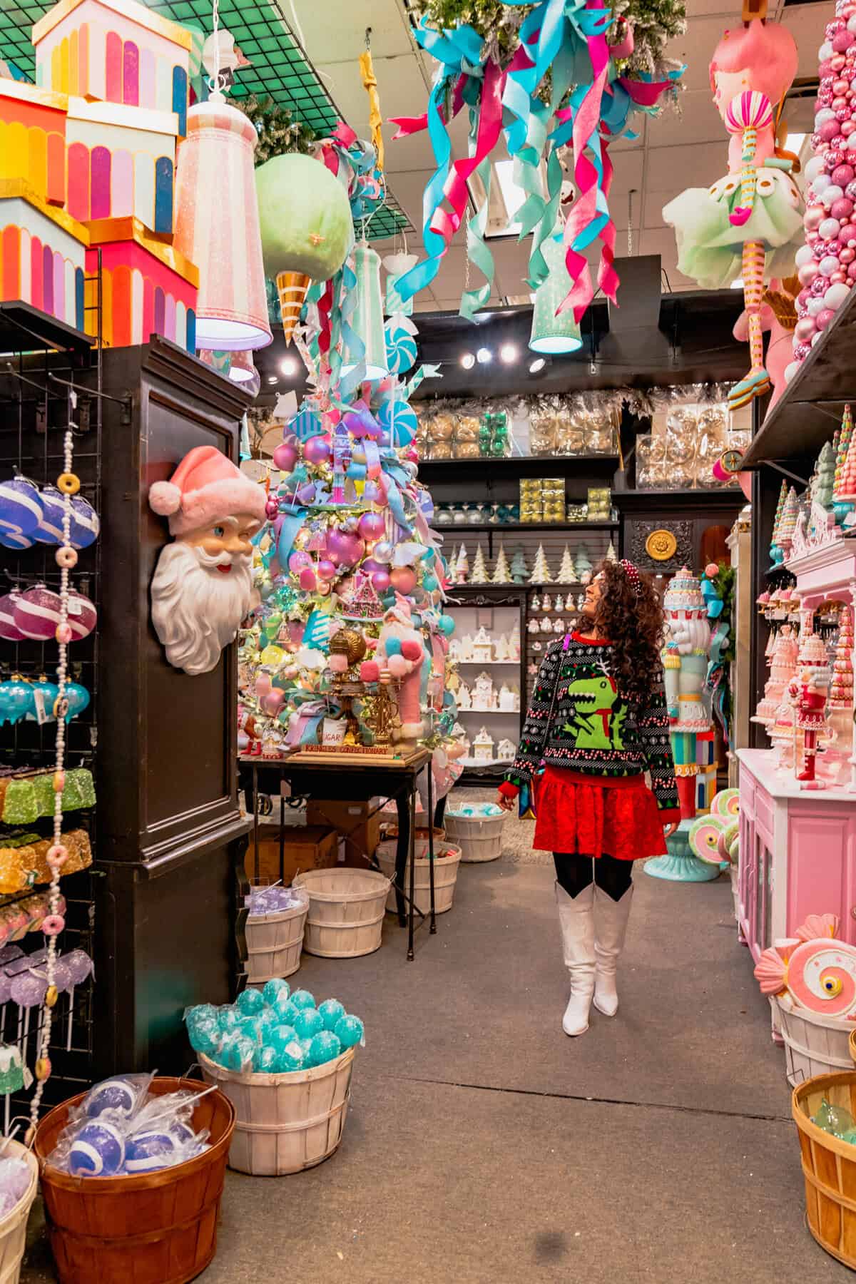 A woman strolls through a store, surrounded by colorful Christmas decorations