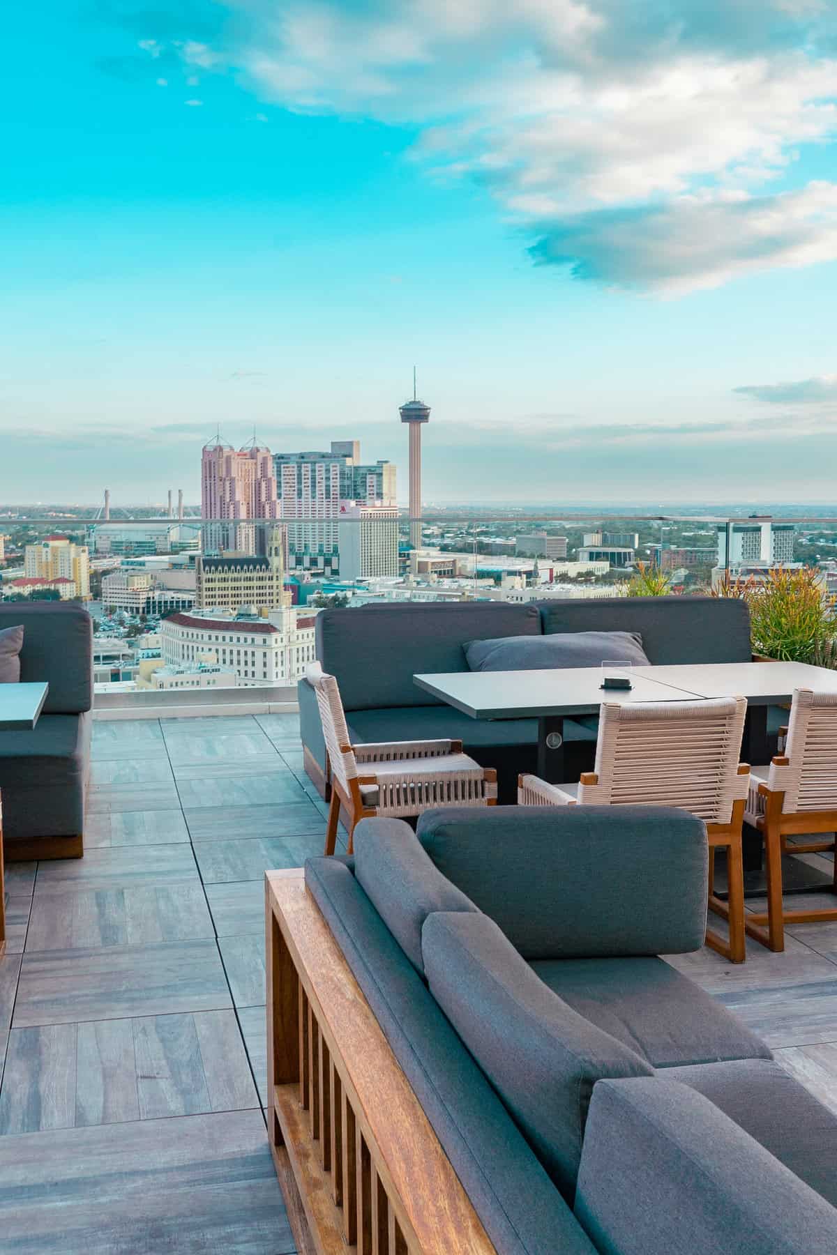 Rooftop lounge with modern seating overlooking a vibrant city skyline