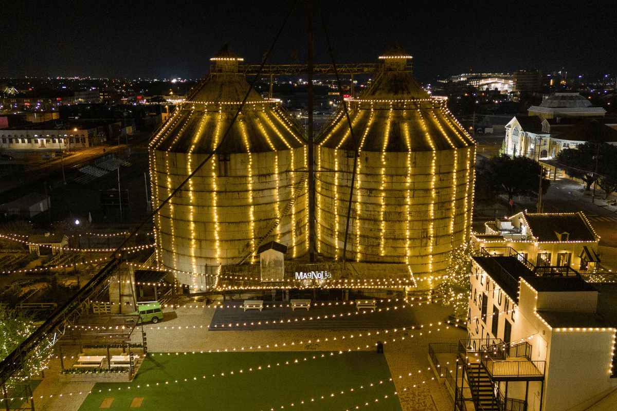 Nighttime aerial perspective of a large grain silo, beautifully lit up