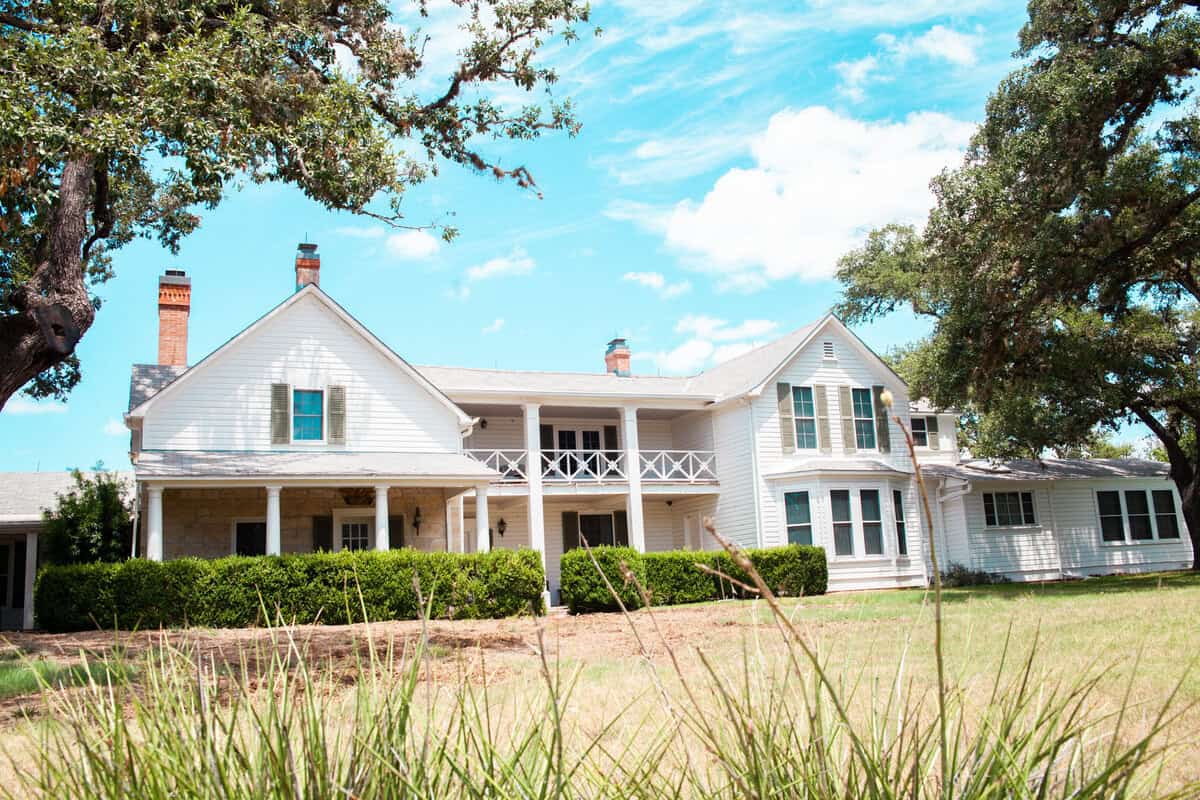 A large white house with a porch and balcony