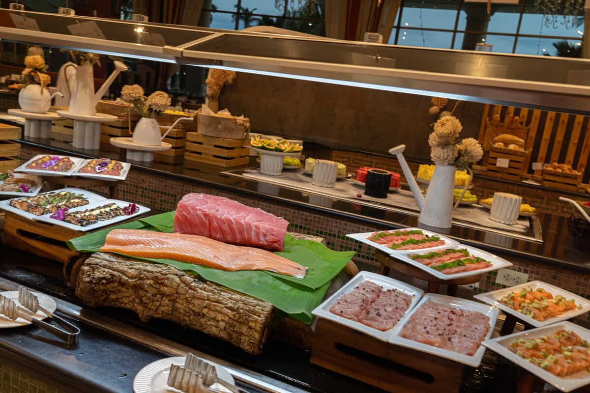 A buffet display featuring fresh sushi, sashimi, and various seafood