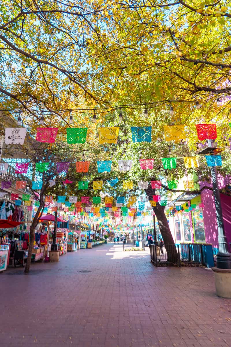 A vibrant street lined with colorful papel picado banners