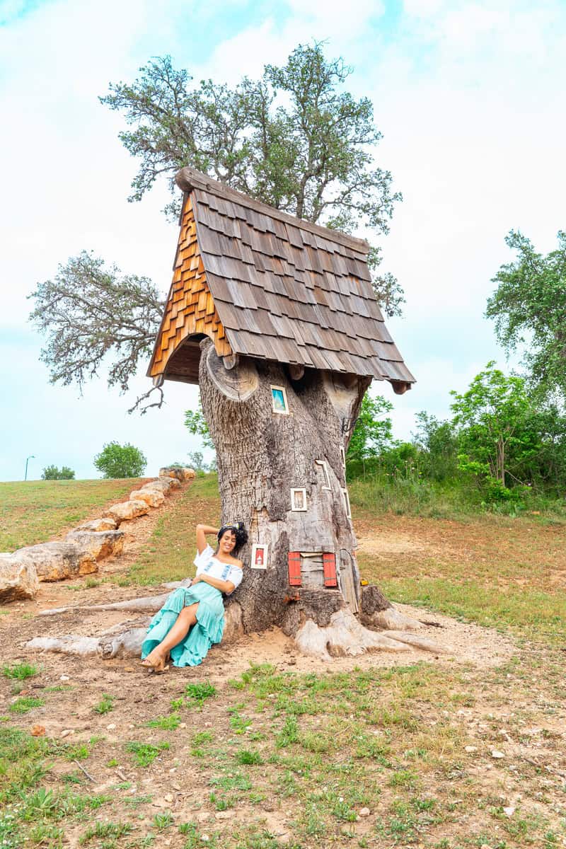 A unique tree house with a wooden shingled roof and small windows