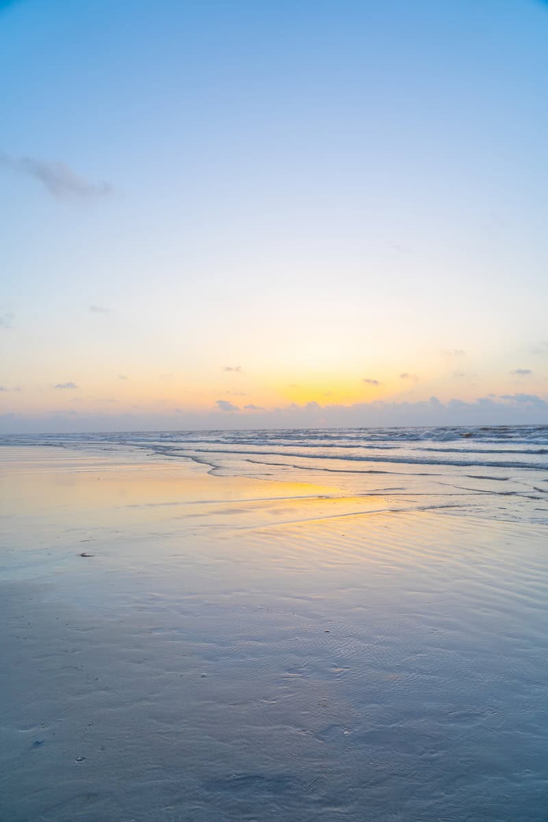 A serene beach scene at sunset with gentle waves