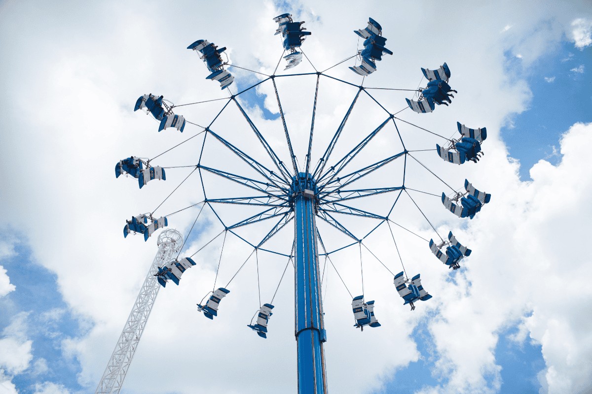 An amusement park swing ride spins 