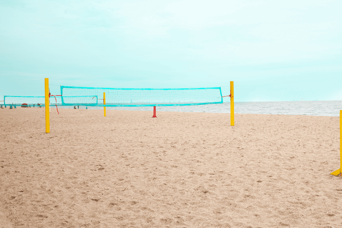 Two beach volleyball nets with bright yellow poles stand