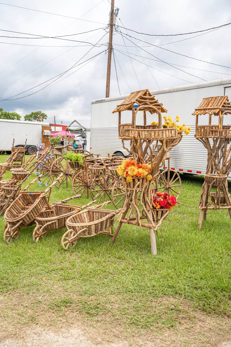 A display of rustic wooden garden decor, including wheelbarrows
