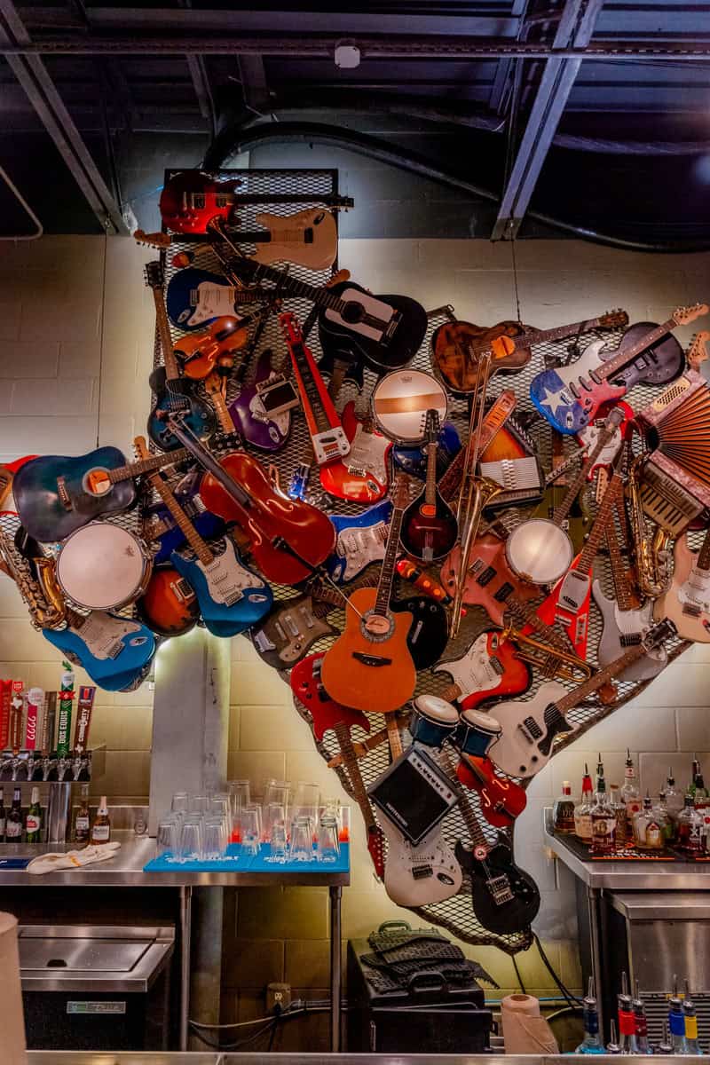 A vibrant wall art installation of various guitars and musical instruments