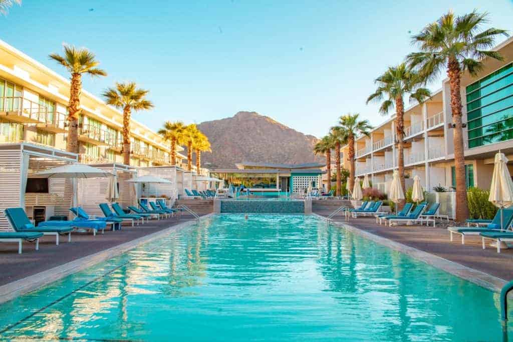 A serene hotel pool surrounded by palm trees and lounge chairs