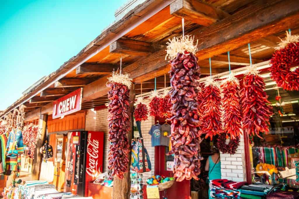 Vibrant hanging red chilies adorn a rustic market entrance