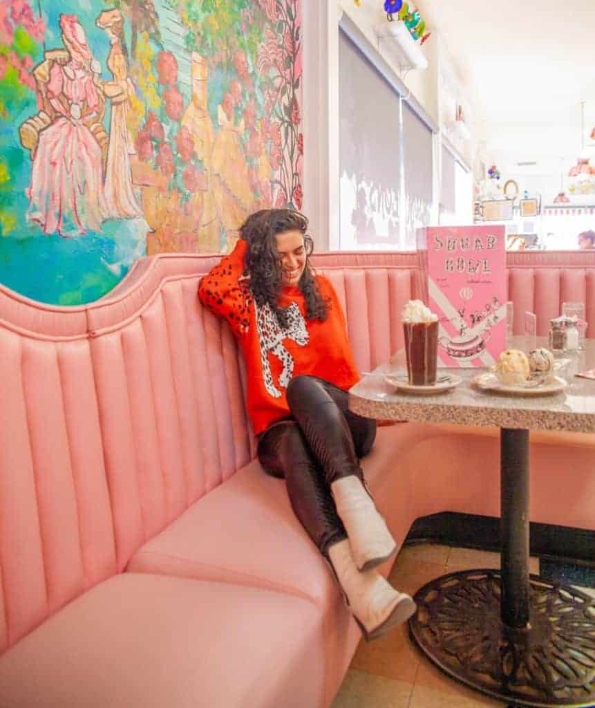 A cozy pink booth in a café, with a colorful mural