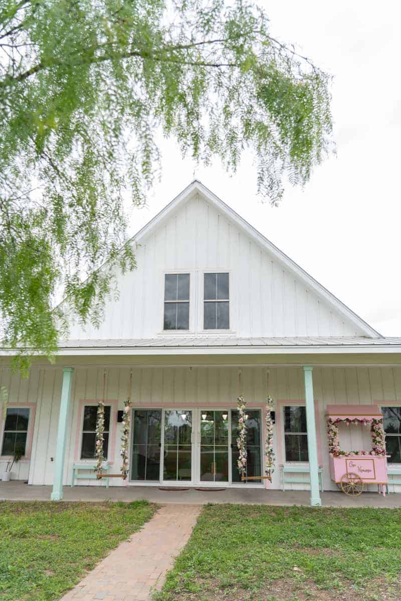 White two story house with two floral swings perfect if you want some picnic areas in Casa Kumwesu