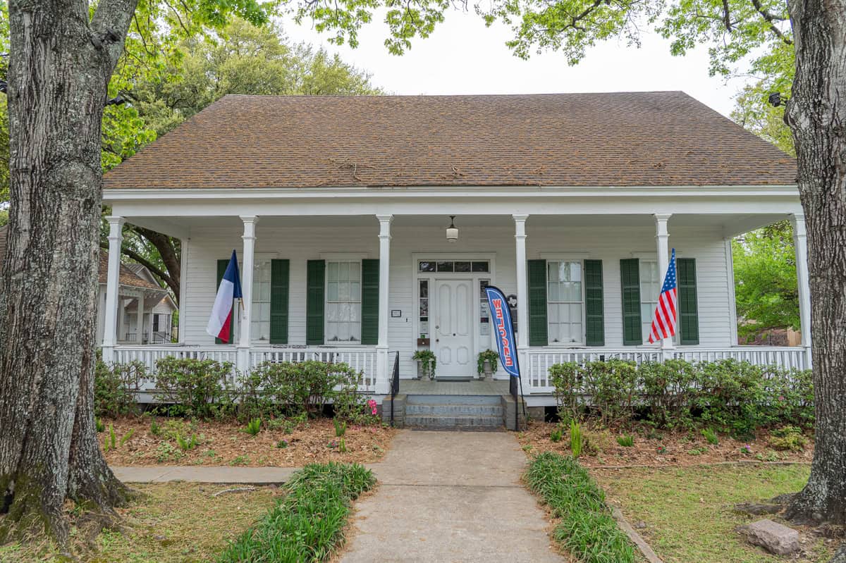 The Griffin house, flanked by American and Texas flags in Tomball Museum Center