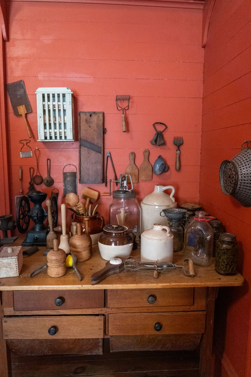 A wooden kitchen table displays vintage tools and jars inside the Griffin House in Tomball Museum Center