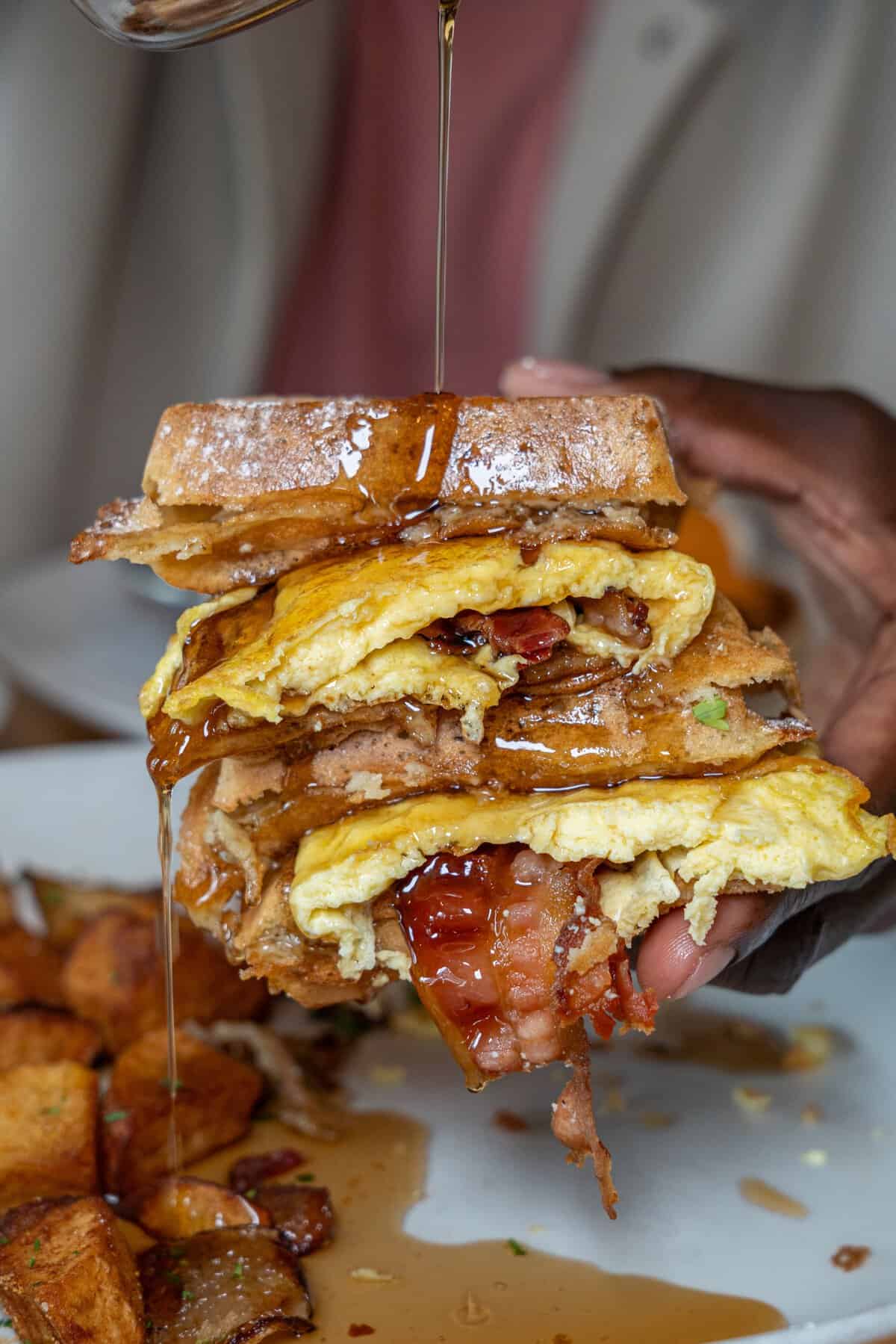 Waffle breakfast sandwich with syrup at Katz's Never Kloses