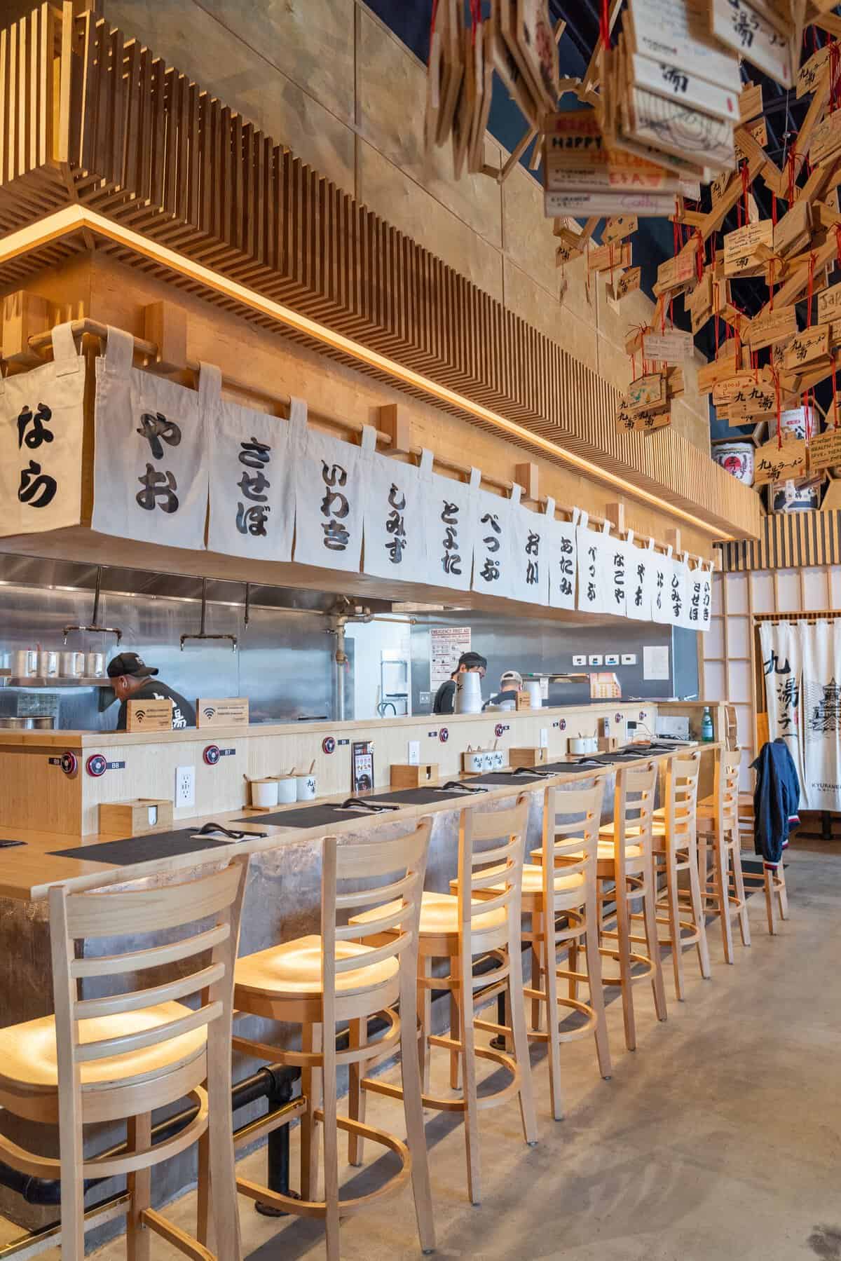 Counter seating and warm wood interior at Kyuramen