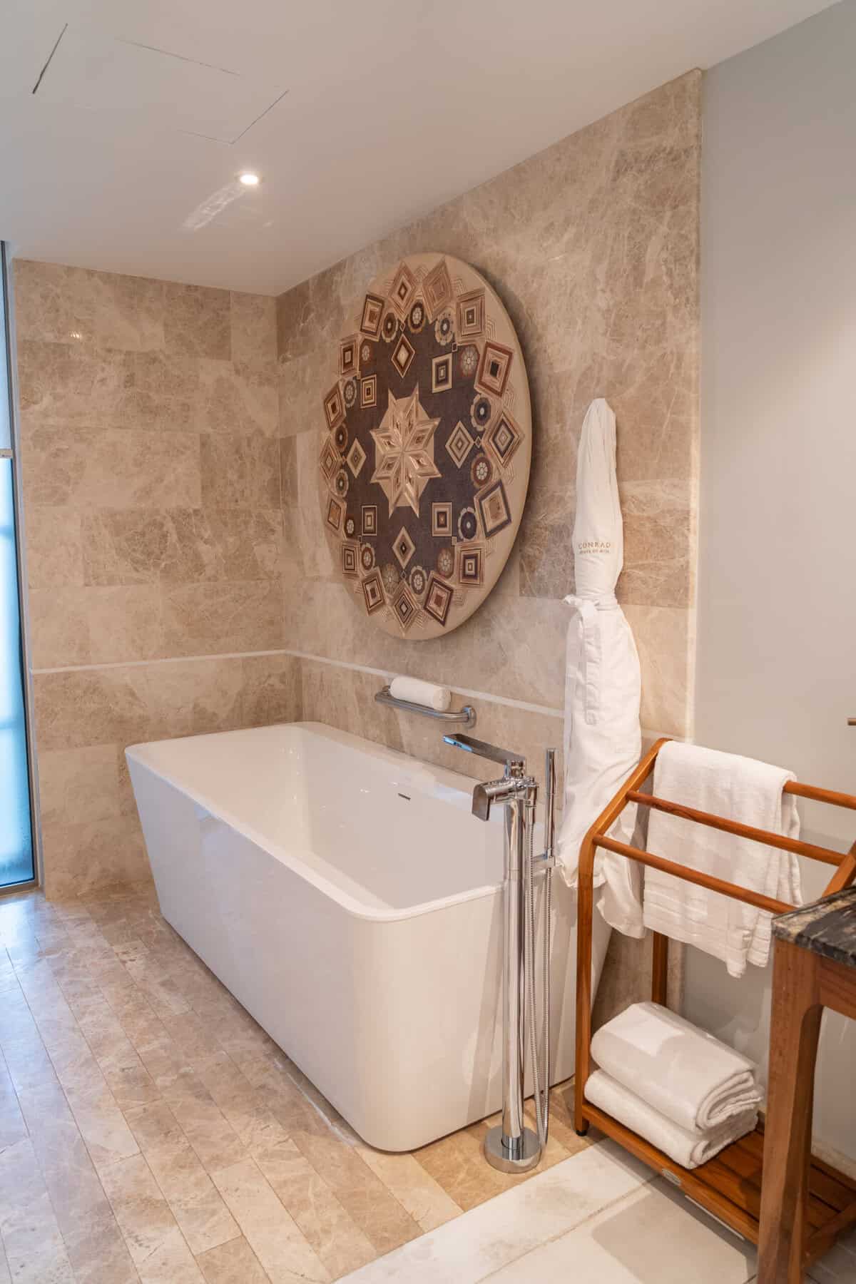 Soaking tub and wall art in the suite bathroom at Conrad Punta de Mita.