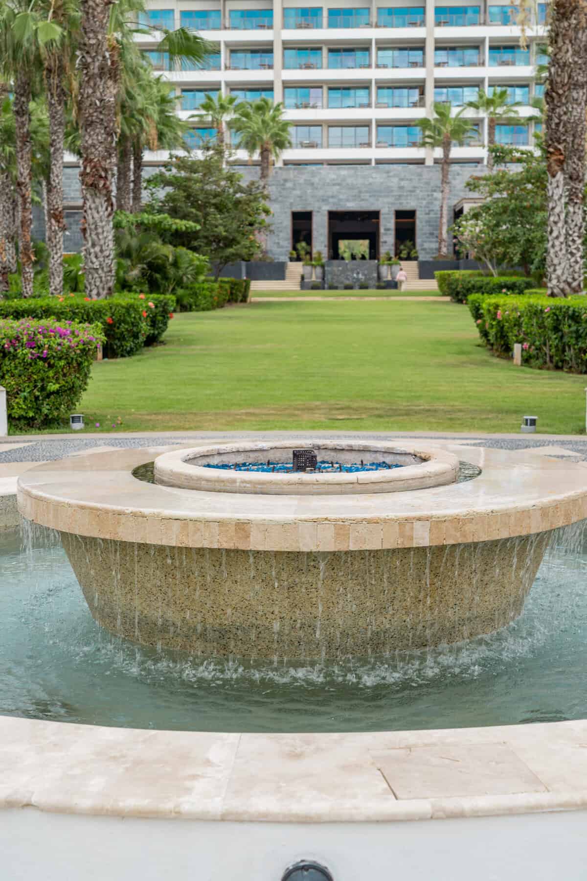 Central lawn and fountain at Conrad Punta de Mita with the resort buildings behind it.