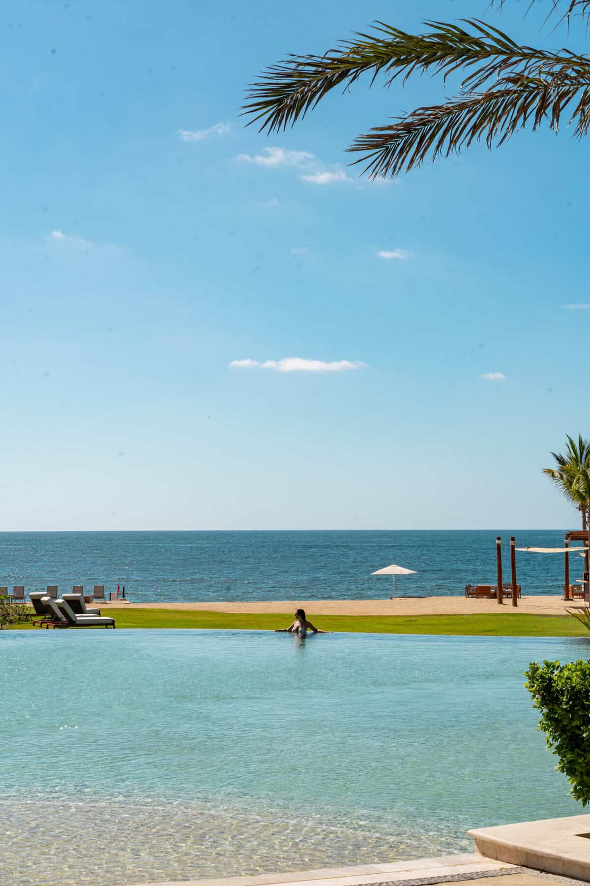 Guest relaxing in the infinity pool facing the ocean at Conrad Punta de Mita.
