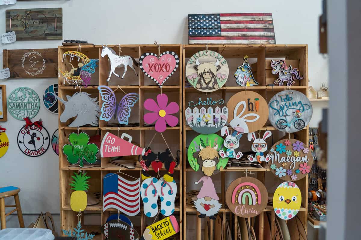 A colorful wall of handmade signs and decor at Craft Chicks in Tomball