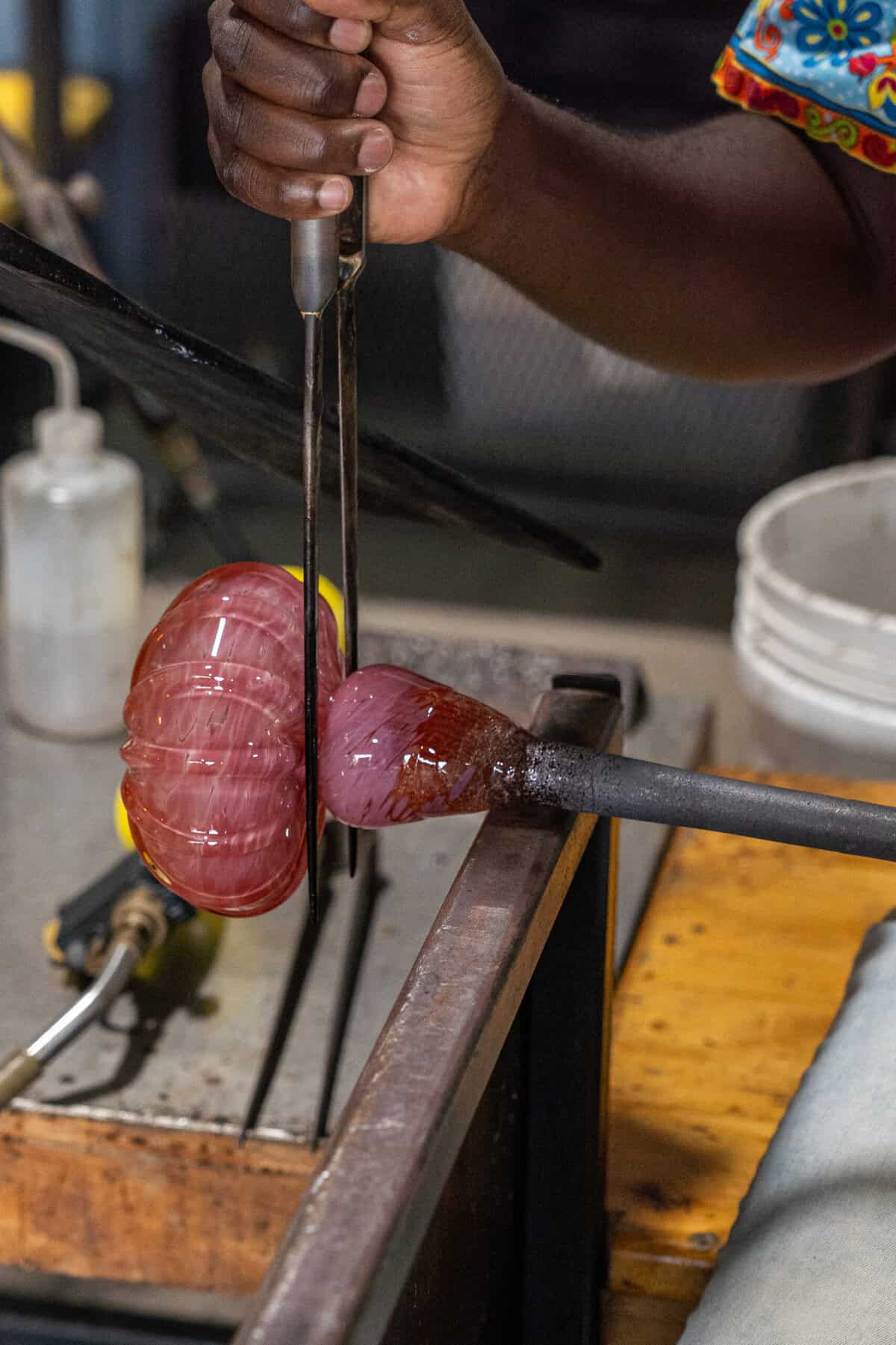 A glass pumpkin being shaped during a class at Houston Glassblowing