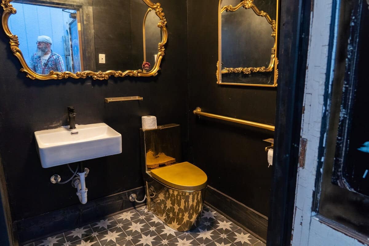Gold-painted bathroom inside Old Tomball Honky Tonk