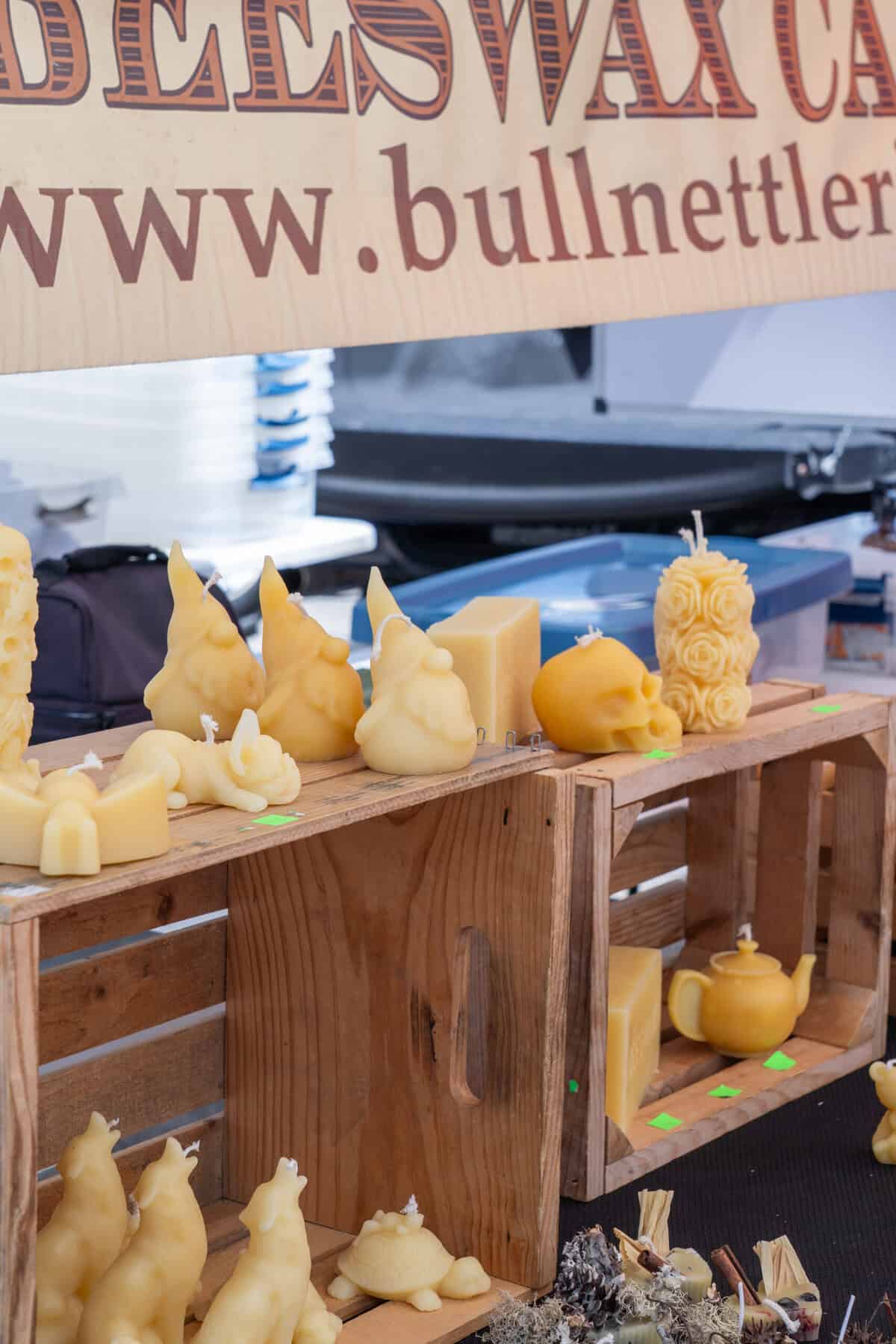 Handcrafted candles and carved wax figures are displayed at the Tomball Farmers Market.